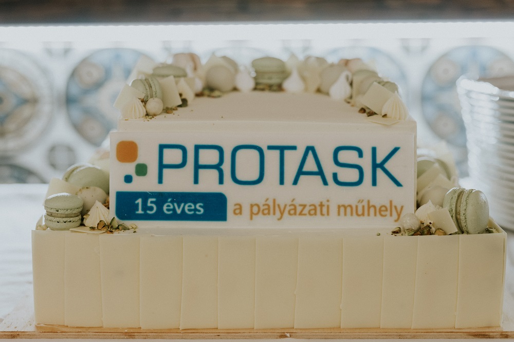 Macaronokkal díszített, Protask kft. logós, pisztáciás emeletes torta